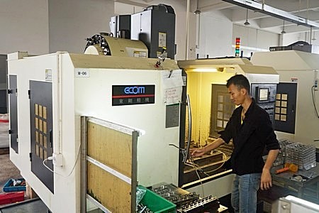 machinist operates a CNC milling machine